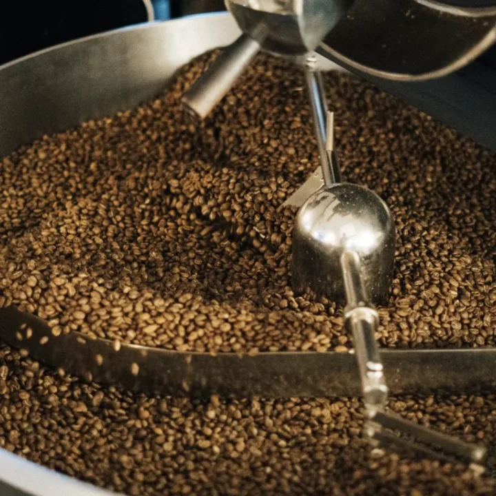 Granos de cafe girando en el tambor de la tostadora.